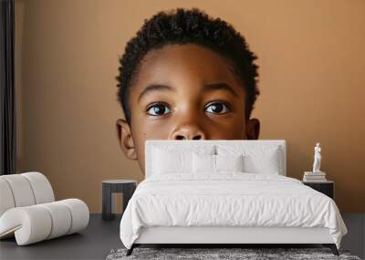 Portrait of a child black boy against a light brown background Wall mural