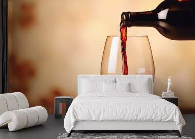 Pouring red wine into glass from bottle. Blurred background Wall mural