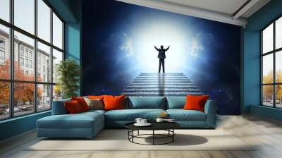 A man in a suit with arms outstretched on a stone staircase to the clouds and light. Stairway to Heaven. Wall mural