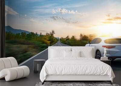 A white car drives along a beautiful road on a sunny summer day. Wall mural