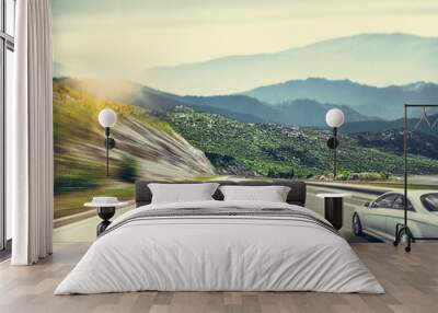 A white car on the road against the backdrop of a beautiful countryside landscape. Wall mural