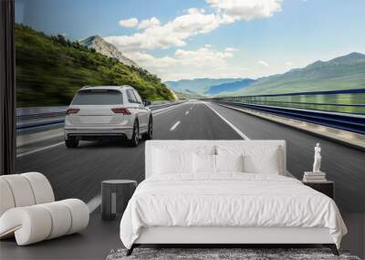 A white car rushing along a high-speed highway in the sun. Wall mural