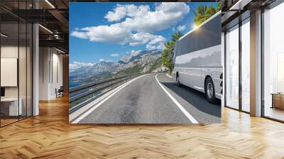 A white tourist bus rides along the highway against the backdrop of a beautiful sea landscape. Wall mural