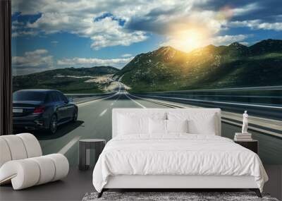 Black car rushing along a high-speed highway in the sun. Wall mural