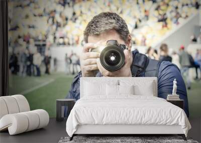 Photographer takes a photo at the stadium. Wall mural