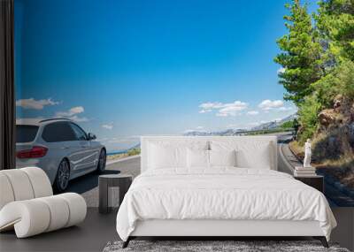 White car on a scenic road. Car on the road surrounded by a magnificent natural landscape. Wall mural