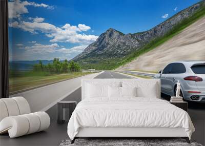 White car on a scenic road. Car on the road surrounded by a magnificent natural landscape. Wall mural