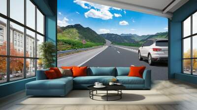 White car on a scenic road. Car on the road surrounded by a magnificent natural landscape. Wall mural