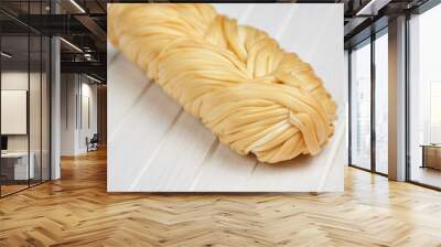 Smoked braided cheese on a white wood background Wall mural