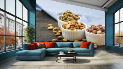 Tasty nuts arrangement in a bowl on a wooden table. Healthy food and snack, organic vegetarian food. Walnut, almond, peanut Wall mural