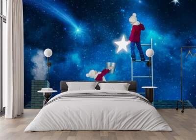 Two brothers in Christmas night standing on the roof of the house and collect the stars from the sky in a bucket.Merry Christmas . Wall mural