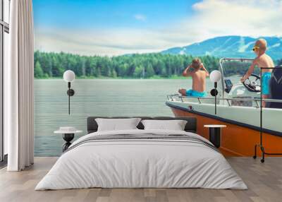 Two brothers swim on a motor boat on the lake. Wall mural