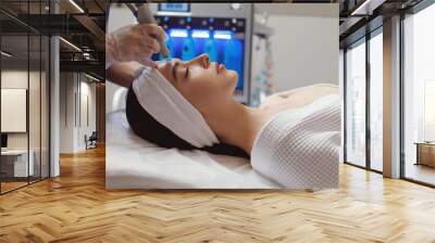 Side view of woman receiving microdermabrasion therapy on forehead at beauty spa Wall mural