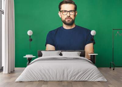 A portrait of young handsome man in casual isolated on green background with glasses. Wall mural