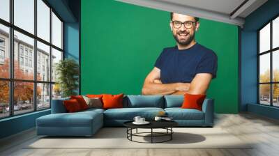 A portrait of young handsome man in casual isolated on green background with glasses. Wall mural