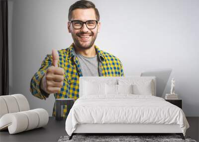 Confident business expert. Confident young handsome man in shirt holding laptop and smiling while standing against white background. Sign super. Wall mural