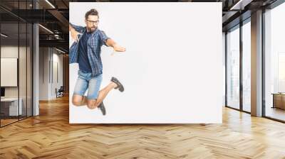 Happy excited cheerful young man jumping and celebrating success isolated on a white background Wall mural