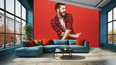 Photo of handsome young man dancing isolated over red wall background. Wall mural