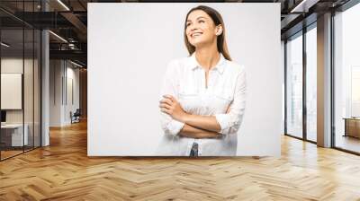 Portrait of happy smiling young beautiful woman, isolated over white background. Looking up. Free space for text. Wall mural