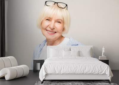 Portrait of mature business woman smile while standing against white background. Photo of old woman wearing glasses. A beautiful modern grandmother is a pensioner. Wall mural