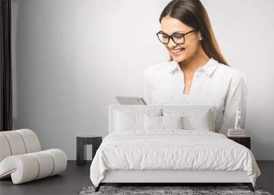 Portrait with copy space empty place of pretty charming confident trendy woman in classic shirt having tablet in hands isolated on white background Wall mural