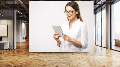 Portrait with copy space empty place of pretty charming confident trendy woman in classic shirt having tablet in hands isolated on white background Wall mural