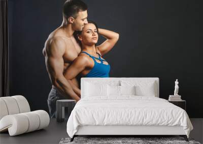 Sporty young sexy couple isolated over black background. Wall mural