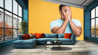 Surprised amazed african american indian man guy in casual isolated over yellow background studio portrait. People lifestyle concept. Mock up copy space. Keeping mouth open. Wall mural