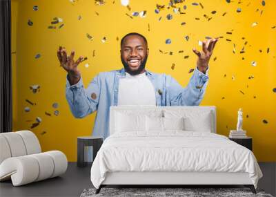 Winner! Cheerful african american young man dancing over yellow background. Wall mural