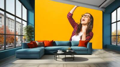 Winning success woman happy ecstatic celebrating being a winner. Dynamic energetic image of multiracial Caucasian Asian female model isolated on yellow background waist up. Wall mural