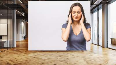 Young beautiful woman over isolated background suffering from headache desperate and stressed because pain and migraine. Hands on head. Wall mural