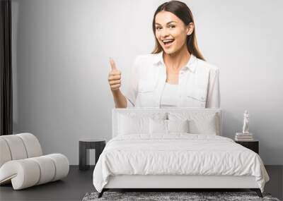 Young happy cheerful woman showing thumb up. Confident young businesswoman giving the thumbs up against a white background. Place for text. Wall mural