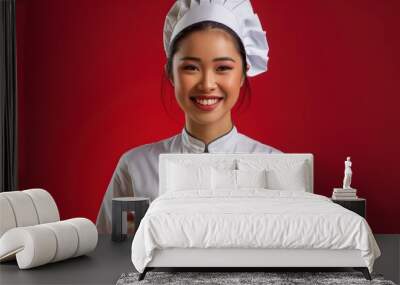 A smiling young chef presents a beautifully plated gourmet meal with colorful vegetables Wall mural