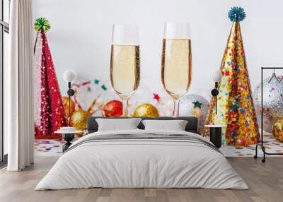 Festive new year items are arranged with champagne glasses, glittering decorations, and colorful party hats, capturing a celebratory atmosphere Wall mural