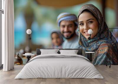 islamic family eating together at outdoor restaurant on arabian beach Wall mural