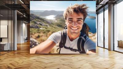 Young man with a backpack taking a selfie on a mountain Wall mural