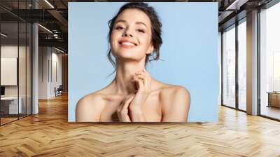 Beautiful brunette  girl with glowing hydrated facial skin touching healthy palm. Skincare and cosmetology Wall mural