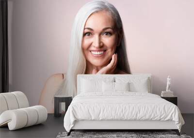 gray-haired woman looking at camera. positive single mature senior retired woman touching healthy gr Wall mural