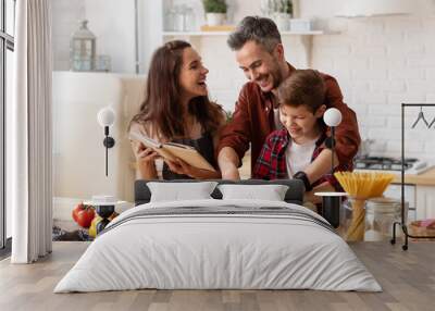 Happy family laughing loud and cooking on kitchen Wall mural