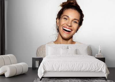 Portrait of cheerful model laughing at something. Pretty young woman in beige pullover. Brunette girl in good mood. Happiness and beauty concept. Isolated on white background Wall mural