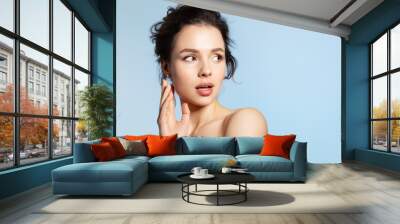 Shocked young beautiful woman with perfect skin and mouth open looking back.  Wall mural