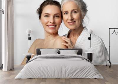 Two tender beautiful women of different ages and generations together on a white background. The daughter and her elderly mother are smiling. Wall mural