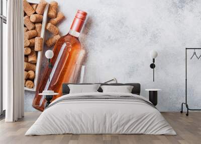 Bottle and glasses of pink rose wine with box of corks and corkscrew opener on stone kitchen table background. Top view. Space for text Wall mural