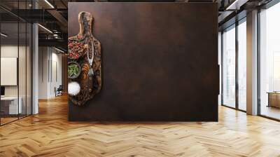 Chopping board with salt,pepper and rosemary with barbeque steel fork on brown kitchen table background. Wall mural