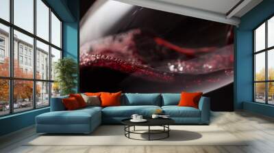 Close up of crystal glass of red wine with bubbles on black. Wall mural