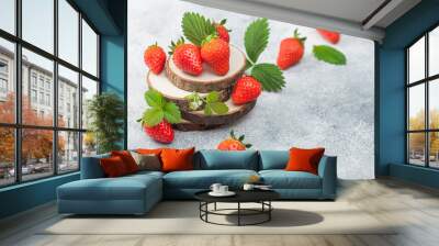 Fresh raw organic summer strawberries with a lot of vitamins and leaf on round timber boards on light background. Wall mural