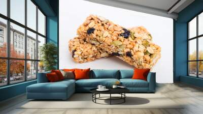 Homemade organic granola cereal bars with nuts and dried fruit on white background Wall mural