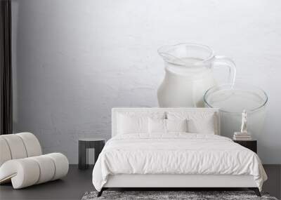 Jar and glass of milk and bowl of sour cream on white stone kitchen table background.Space for text Wall mural