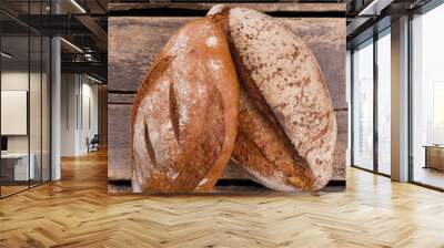 Fresh natural wheat bread. Two loaves of homemade bread on vintage wooden background. Wall mural