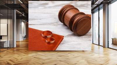 Judge gavel and wedding rings. White wood background. Wall mural